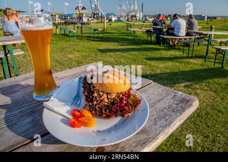 Tipico rotolo di granchio con una birra nel birreria all'aperto del Siebhaus am Kutterhafen, Brema, località balneare del Mare del Nord, costa del Mare del Nord di Wurster, estuario di Weser Foto Stock