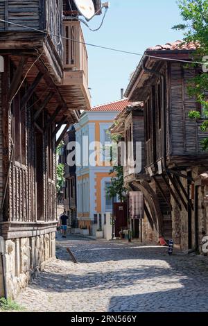 Case a graticcio con tipico tetto sporgente sulla strada acciottolata della città vecchia. Sozopol, Burgas, Bulgaria, Europa sudorientale Foto Stock