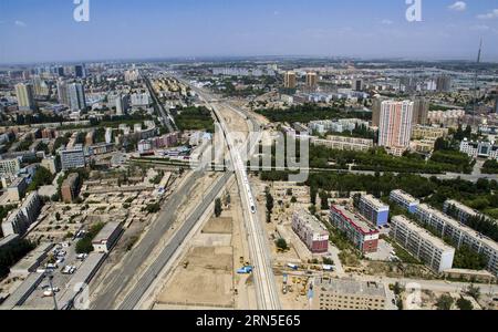 (150623) -- URUMQI, 23 giugno 2015 -- foto scattata con un drone il 21 maggio 2015 mostra un treno proiettile che attraversa la città di Hami, nella regione autonoma di Xinjiang Uygur della Cina nord-occidentale. La ferrovia ad alta velocità di Lanxin, lunga 1.776 chilometri, fu messa in funzione il 26 dicembre 2014, collegando Lanzhou, capitale della provincia di Gansu, Xining, capitale della provincia di Qinghai, e Urumqi, tutte nel nord-ovest della Cina. Nel 2015, foto aeree della sezione Xinjiang della ferrovia ad alta velocità di Lanxin sono state scattate da un gruppo di fotografia aerea dell'Agenzia di notizie Xinhua e varie forme di terra dello Xinjiang sono state registrate. P) CHINA-LANXIN HIG Foto Stock