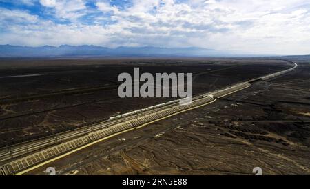 (150623) -- URUMQI, 23 giugno 2015 -- foto scattata con un drone il 19 maggio 2015 mostra un treno proiettile che attraversa il deserto del gobi a Turpan, nella regione autonoma di Xinjiang Uygur della Cina nord-occidentale. La ferrovia ad alta velocità di Lanxin, lunga 1.776 chilometri, fu messa in funzione il 26 dicembre 2014, collegando Lanzhou, capitale della provincia di Gansu, Xining, capitale della provincia di Qinghai, e Urumqi, tutte nel nord-ovest della Cina. Nel 2015, foto aeree della sezione Xinjiang della ferrovia ad alta velocità di Lanxin sono state scattate da un gruppo di fotografia aerea dell'Agenzia di notizie Xinhua e varie forme di terra dello Xinjiang sono state registrate. (p) CHINA-L. Foto Stock