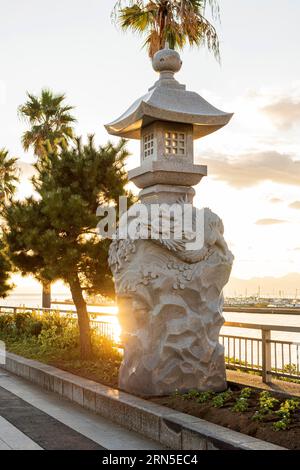 Lanterne di pietra con draghi alla luce della sera, Ponte Enoshima Benten, Fujisawa, Prefettura di Kanagawa Foto Stock