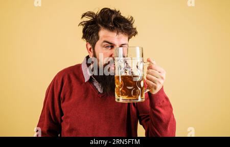 Beer degustation. Drunk bearded man with mug of beer. Oktoberfest celebration. Handsome bearded hipster tasting fresh brewed beer. Drink, alcohol and Stock Photo