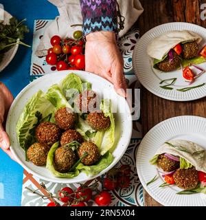 Mani da vicino che tengono il piatto con cibo ebraico Foto Stock