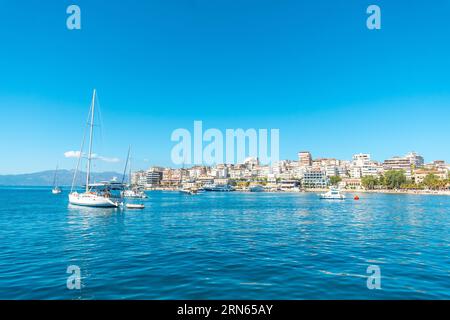 Barche turistiche sulle spiagge della città di Sarande o Saranda sulla riviera albanese viste da una barca, l'Albania Foto Stock