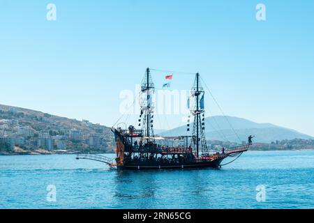 Barche turistiche sulle spiagge della città di Sarande o Saranda sulla riviera albanese viste da una barca, l'Albania Foto Stock