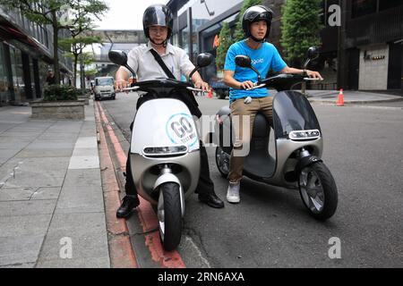 (150718) -- TAIPEI, - Un cittadino (L) prova su una moto gogoro o Smartscooter a Taipei, nel sud-est della Cina a Taiwan, 17 luglio 2015. Lo Smartscooter è progettato per essere in grado di percorrere 100 chilometri a una velocità di 40 chilometri all'ora, alimentato da due batterie. I clienti possono ottenere batterie completamente cariche sostituendo le batterie presso 32 stazioni di sostituzione delle batterie a Taipei. Il numero delle stazioni dovrebbe salire a 150 entro la fine di quest'anno. ) (lfj) CHINA-TAIPEI-GOGORO-SMARTSCOOTER (CN) CaixYang PUBLICATIONxNOTxINxCHN 150718 Taipei a Citizen l trial guida una motocicletta o a Taipei South EA Foto Stock