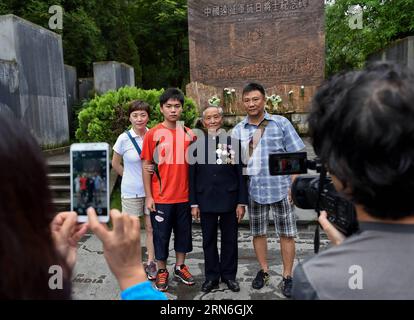 (150727) -- PECHINO, 27 luglio 2015 -- Lu Caiwen (2nd R) posa per una foto di gruppo con i visitatori al cimitero di Guoshang a Tengchong, nella provincia dello Yunnan della Cina sud-occidentale, 21 luglio 2015. Nel cimitero di Guoshang, nella contea di Tengchong, nella provincia dello Yunnan, Lu Caiwen, un veterano di 90 anni, alzò lentamente la mano destra per rendere omaggio ai suoi compagni d'armi che morirono in battaglia nel campo di battaglia nella provincia occidentale dello Yunnan 70 anni fa. Lu era un collezionista di informazioni di intelligence, un lavoro ad alto rischio durante la Guerra di resistenza popolare cinese contro le aggressioni giapponesi. Ho partecipato in Cina Foto Stock