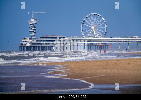 Il molo e la ruota panoramica presso lo stand di Scheveningen, strong Swell, Paesi Bassi Foto Stock