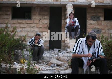 (150730) - GERUSALEMME, 30 luglio 2015 -- i coloni ebrei israeliani pregano nell'insediamento di sa-Nur nella Cisgiordania settentrionale, il 30 luglio 2015. Giovedì le forze di sicurezza israeliane hanno evacuato circa 200 coloni dal sito dell'ex insediamento illegale di sa-Nur nella Cisgiordania settentrionale, ha affermato un portavoce militare in una dichiarazione. Da quando sa-Nur è stata evacuata come parte del piano di disimpegno del 2005 da Gaza, gli ex residenti di sa-Nur hanno fatto diversi tentativi per ricostruire il loro insediamento. /MIRI TZACHI) ISRAELE FUORI MIDEAST-CISGIORDANIA-INSEDIAMENTO ILLEGALE-EVACUAZIONE JINI PUBLICATIONXNOTXINXCH Foto Stock