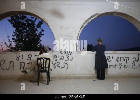 (150730) - GERUSALEMME, 30 luglio 2015 -- i coloni ebrei israeliani pregano nell'insediamento di sa-Nur nella Cisgiordania settentrionale, il 30 luglio 2015. Giovedì le forze di sicurezza israeliane hanno evacuato circa 200 coloni dal sito dell'ex insediamento illegale di sa-Nur nella Cisgiordania settentrionale, ha affermato un portavoce militare in una dichiarazione. Da quando sa-Nur è stata evacuata come parte del piano di disimpegno del 2005 da Gaza, gli ex residenti di sa-Nur hanno fatto diversi tentativi per ricostruire il loro insediamento. /MIRI TZACHI) ISRAELE FUORI MIDEAST-CISGIORDANIA-INSEDIAMENTO ILLEGALE-EVACUAZIONE JINI PUBLICATIONXNOTXINXCH Foto Stock