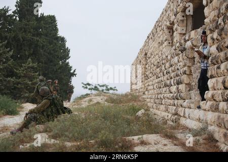 (150730) - GERUSALEMME, 30 luglio 2015 - un colono ebreo israeliano prega mentre le forze di sicurezza israeliane sorvegliano l'insediamento di sa-Nur nella Cisgiordania settentrionale, il 30 luglio 2015. Giovedì le forze di sicurezza israeliane hanno evacuato circa 200 coloni dal sito dell'ex insediamento illegale di sa-Nur nella Cisgiordania settentrionale, ha affermato un portavoce militare in una dichiarazione. Da quando sa-Nur è stata evacuata come parte del piano di disimpegno del 2005 da Gaza, gli ex residenti di sa-Nur hanno fatto diversi tentativi per ricostruire il loro insediamento. /MIRI TZACHI) ISRAELE FUORI MIDEAST-CISGIORDANIA-ILLEGALE SETTLEMEN Foto Stock