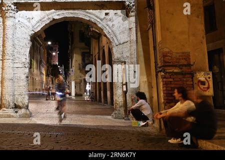 Italien, Verona Una donna cavalca sotto la porta Borsari a Verona il 27 luglio 2015. Verona è una città del Veneto. Essendo una delle principali destinazioni turistiche del nord Italia, la città ha patrimoni artistici, fiere annuali, spettacoli e opere. Nel 2000 è stato dichiarato patrimonio dell'umanità dall'UNESCO per i suoi edifici storici. ITALIA-VERONA-DAILY LIFE JinxYu PUBLICATIONxNOTxINxCHN Foto Stock