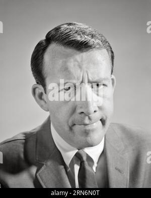 RITRATTO DEGLI ANNI '1960 DI UN UOMO CHE INDOSSA TUTA E CRAVATTA E CHE ESPRIME UN'INFELICE ESPRESSIONE FACCIALE INSODDISFATTA GUARDANDO LA FOTOCAMERA - P7268 HAR001 HARS COPIA SPAZIO PERSONE MASCHI ESPRESSIONI TURBATE B&W PREOCCUPATO FRUSTRATA TRISTEZZA OCCHIO CONTATTO TESTA E SPALLE ANGOSCIATO IRATO E UMORE GLUM DISPIACERE OSTILITÀ ALIMENTATO FASTIDIO EMOZIONE EMOTIVO IRRITATO MID-ADULT MID-ADULT UOMO MISERA NERO E BIANCO ETNIA CAUCASICA SCONTENTO HAR001 VECCHIO STILE Foto Stock