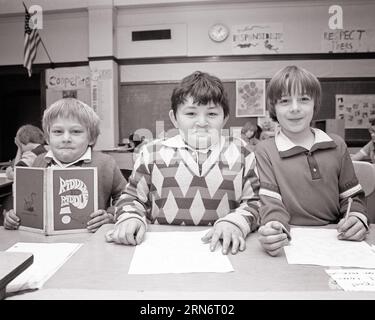 1970S 1980S TRE RAGAZZI A SCUOLA IN CLASSE DIVERTENTE SORRIDENTE ESPRESSIONI FACCIALI UN BAMBINO STA TENENDO UN LIBRO RDDLE - S21867 HAR001 HARS STILE FACCIALE ELEMENTARE BENVENUTO COMUNICAZIONE VARIEGATA AMICO FUMETTO DIVERSO PIACERE PIACERE STILE DI VITA SODDISFAZIONE SPAZIO COPIA AMICIZIA MEZZA LUNGHEZZA I MASCHI ESPRESSIONI B&W CONTATTO CON GLI OCCHI LE SCUOLE CLASSIFICANO LA FELICITÀ UMORISTICA L'AVVENTURA ALLEGRA L'ECCITAZIONE ORIENTALE COMICO ASIATICO AMERICANO SORRISI PRIMARI CONNESSIONE COMMEDIA SIMPATICO SUPPORTO GIOIOSO VARI INDOVINELLO COOPERAZIONE ASIATICA-AMERICANA GIOVANILI DI SCUOLA INSIEME COMPAGNI DI CLASSE DI ETNIA CAUCASICA BIANCA E NERA Foto Stock