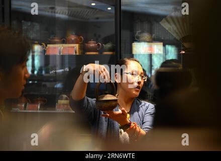 (150808) -- LHASA, - Yu Ya chi introduce una teiera nella sua casa da tè a Lhasa, capitale della regione autonoma del Tibet del sud-ovest della Cina, 7 agosto 2015. Entrando nella casa del tè Yushan Taiwan di Yu Ya chi a Lhasa, la gente potrebbe essere attratta dal suo ambiente tranquillo, dalla decente cerimonia del tè e dal sapore del tè oolong di Taiwan. Provenendo da Taichung, città del sud-est della Cina, Yu Ya chi è a Lhasa da 12 anni. È in grado di parlare fluentemente la lingua tibetana e conoscere pienamente la cultura buddista. Yu prega anche al Palazzo Potala con i residenti tibetani locali e legge libri tibetani e buddisti come un re Foto Stock