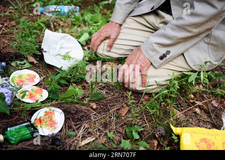 MUDANJIANG, 10 agosto 2015 -- 73 Yohachi Nakajima, un orfano di guerra rimasto in Cina dopo la seconda guerra mondiale, si inginocchiò davanti alla tomba dei suoi genitori adottivi nella città di Mudanjiang, nella provincia di Heilongjiang della Cina nord-orientale, 10 agosto 2015. Nakajima si recò nella provincia di Heilongjiang nel nord-est della Cina nel 1942 con la sua famiglia come membri del gruppo di coloni giapponesi quando era solo un bambino di un anno. Ma nel 1945, quando il Giappone militarista si arrese alla fine della seconda guerra mondiale, fu lasciato solo in Cina. Una contadina cinese locale adottò Nakajima, una bambina dell'ex nemico. Lei cura Foto Stock