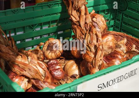 Mazzo di aglio affumicato in un cestino, delizioso condimento al ristorante, mercato agricolo, prodotti agricoli Foto Stock