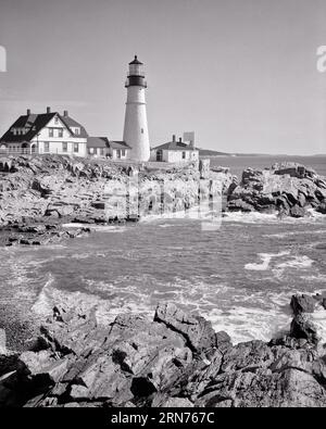 1960s PORTLAND HEAD LIGHTHOUSE COMPLETED IN 1791 CAPE ELIZABETH MAINE USA  - l2308 HAR001 HARS RISK BUILDINGS TRANSPORTATION B&W LENS NORTH AMERICA ME NORTH AMERICAN TOWER SHORE ROCKY STRUCTURE URBAN CENTER PROTECTION ELIZABETH EXTERIOR LOW ANGLE WARNING GUIDING NORTHEAST GUIDING LIGHT LIGHT HOUSE GUARDIANS LIGHT HOUSES LIGHTHOUSE SERVICE PORTLAND ROCKS CAPE ELIZABETH LIGHTHOUSE CONCEPTUAL EAST COAST COMPLETED FORT WILLIAMS PARK GUARDIAN WARN CASCO BAY GULF OF MAINE HISTORIC LANDMARK LIGHTHOUSES NEW ENGLAND PORTLAND HARBOR SCENICS SIGNATURE STRUCTURE TOURIST ATTRACTION 1791 BLACK AND WHITE Stock Photo