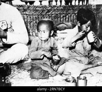 (150902) - PECHINO, - la foto del file non datato mostra i bambini cinesi che mangiano avanzi in un campo di prigionia in Cina. Durante la guerra dell'aggressione giapponese alla Cina durante la seconda guerra mondiale, circa 2,2 milioni di bambini cinesi furono uccisi o feriti dagli invasori giapponesi. I bambini cinesi hanno sofferto per il disagio delle case, la minaccia di morte e la perdita dei genitori. I crimini commessi dall'esercito giapponese portarono alla vita di un bambino eventi che non avrebbero dovuto vivere. () (zkr) (LENTE SCURA)CHINA-WWII-JAPANESE AGGRESSION-CHILDREN(CN) Xinhua PUBLICATIONxNOTxINxCHN 150902 Beijing undated file Photo Shows Foto Stock