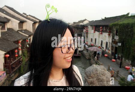 (150908) -- SUZHOU, 8 settembre 2015 -- Un visitatore posa per foto con decorazione floreale dei capelli in una strada a Suzhou, nella provincia di Jiangsu della Cina orientale, 6 settembre 2015. La decorazione floreale dei capelli è diventata popolare di recente nelle strade di Suzhou. (Zwx) CHINA-JIANGSU-SUZHOU-HAIR DECORATION(CN) WangxJiankang PUBLICATIONxNOTxINxCHN Suzhou Sept 8 2015 un visitatore posa per foto con decorazione floreale dei capelli IN una strada a Suzhou nella provincia di Jiangsu della Cina orientale Sept 6 2015 la decorazione floreale dei capelli è diventata popolare recentemente NELLE strade di Suzhou zwx China Jiangsu Suzhou Hair Decoration CN WangxJiankang Jiankang PUBLICATIONxNOTx Foto Stock