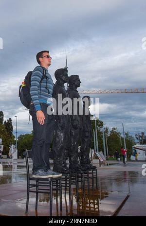 (150914) -- GINEVRA, 14 settembre 2015 -- Un visitatore posa per foto con una scultura intitolata Anything to Say? E composto da figure in bronzo a grandezza naturale di Edward Snowden, Julian Assange e Chelsea Manning sulla Place des Nations di fronte alla sede europea delle Nazioni Unite a Ginevra, in Svizzera, 14 settembre 2015. Le figure in bronzo, realizzate dallo scultore italiano Davide Dormino, saranno esposte in piazza fino a venerdì. ) SVIZZERA-GINEVRA-SCULTURA XuxJinquan PUBLICATIONxNOTxINxCHN 150914 Ginevra 14 settembre 2015 un visitatore posa per foto con una scultura intitolata Anything to Say and Foto Stock