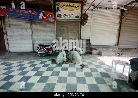 Peshawar, Peshawar, Pakistan. 31 agosto 2023. La gente siede di fronte a un mercato chiuso dopo che i commercianti hanno chiesto uno sciopero per protestare contro l'inflazione a Peshawar, Pakistan, il 31 agosto 2023. Le proteste contro le bollette dell'elettricità gonfiate sono scoppiate in diverse città in tutto il Pakistan, con dimostranti che hanno bruciato le bollette mensili, e leader commerciali e rappresentanti che hanno espresso preoccupazioni per le tasse eccessive. Le persone che lottano per sbarcare il lunario sono state colpite duramente da bollette elettriche elevate, e il fallimento del governo nel ridurre i prezzi e le tasse aggiuntive è un problema importante. La Foto Stock