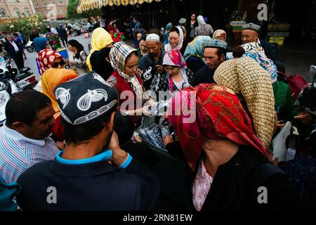 (150930) -- KASHGAR, 30 settembre 2015 -- i residenti scattano vestiti di vendita promozionale nella città vecchia di Kashgar, regione autonoma di Xinjiang Uygur della Cina nordoccidentale, 19 settembre 2015. Kashgar, la città più occidentale della Cina, è stata per secoli il centro della civiltà uigura, un luogo dove le persone si sono riunite per commerciare e diffondere l'apprendimento islamico, sulle rotte carovane dall'Europa e dalla Persia alla Cina. (lfj) CHINA-XINJIANG-KASHGAR-OLD TOWN (CN) ZhangxCheng PUBLICATIONxNOTxINxCHN Kashgar settembre 30 2015 i residenti Snap Up Clothing of Promotional sale nel centro storico di Kashgar nella Cina nordoccidentale di Xin Foto Stock