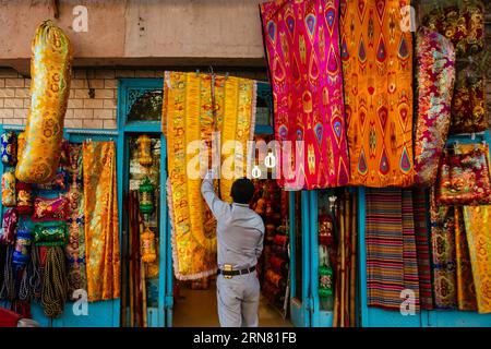 (150930) -- KASHGAR, 30 settembre 2015 -- Un proprietario di un negozio appende un pezzo di coperta nella città vecchia di Kashgar, nella regione autonoma di Xinjiang Uygur della Cina nord-occidentale, 21 settembre 2015. Kashgar, la città più occidentale della Cina, è stata per secoli il centro della civiltà uigura, un luogo dove le persone si sono riunite per commerciare e diffondere l'apprendimento islamico, sulle rotte carovane dall'Europa e dalla Persia alla Cina. (lfj) CHINA-XINJIANG-KASHGAR-OLD TOWN (CN) ZhangxCheng PUBLICATIONxNOTxINxCHN Kashgar settembre 30 2015 un proprietario di un negozio appende un pezzo di coperta nel centro storico di Kashgar, nella Cina nordoccidentale, Nello Xinjiang Uygur Autono Foto Stock