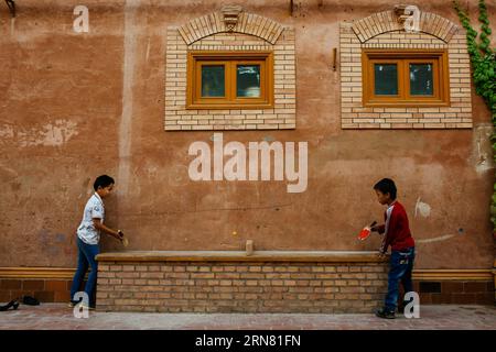 (150930) -- KASHGAR, 30 settembre 2015 -- i bambini giocano a ping pong su un tavolo trasformato da una lunga panchina nella città vecchia di Kashgar, regione autonoma di Xinjiang Uygur, nella Cina nord-occidentale, 20 settembre 2015. Kashgar, la città più occidentale della Cina, è stata per secoli il centro della civiltà uigura, un luogo dove le persone si sono riunite per commerciare e diffondere l'apprendimento islamico, sulle rotte carovane dall'Europa e dalla Persia alla Cina. (lfj) CHINA-XINJIANG-KASHGAR-OLD TOWN (CN) ZhangxCheng PUBLICATIONxNOTxINxCHN Kashgar settembre 30 2015 i bambini giocano a ping pong a un tavolo trasformato da una lunga panchina nel Foto Stock