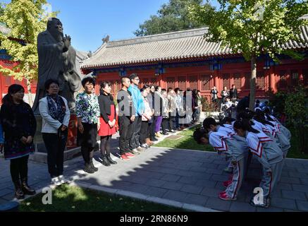 (151009) -- PECHINO, - allievi della scuola elementare Fuxue Hutong si inchinano ai loro genitori e alla statua di Confucio durante una cerimonia d'ingresso alla sala Dacheng del Tempio di Confucio a Pechino, capitale della Cina, 9 ottobre 2015. Una tradizionale cerimonia d'ingresso si è tenuta presso la scuola venerdì. Fondata nel 1368, la Fuxue Hutong Primary School è una scuola moderna caratteristica della cultura tradizionale cinese ed è anche una scuola con il Tempio confuciano conservato fin dai tempi antichi. (mt) CINA-PECHINO-CERIMONIA DI INGRESSO ALLA SCUOLA ELEMENTARE (CN) LuoxXiaoguang PUBLICATIONxNOTxINxCHN 151009 Pechino allievi di Hutong Pr Foto Stock