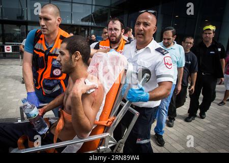 (151013) - GERUSALEMME, 13 ottobre 2015 - il personale di soccorso israeliano evacua un uomo ferito dopo essere stato pugnalato in un parcheggio a Kiryat Ata, nel nord di Israele, il 13 ottobre 2015. Un israeliano ha pugnalato e ferito leggermente un altro israeliano vicino a un negozio IKEA nella città settentrionale di Kiryat Ata. Lo stabber ha detto che stava cercando di vendicare i precedenti attacchi, e ha erroneamente identificato un ebreo di origine mediorientale come arabo. Tre israeliani sono stati uccisi e almeno 15 sono stati feriti in una serie di attacchi a Gerusalemme e nel centro di Israele martedì, nel più grave focolaio di violenza palestinese Foto Stock