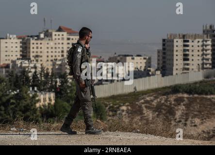 (151014) - GERUSALEMME, 14 ottobre 2015 - un poliziotto di frontiera israeliano pattuglia all'ingresso del quartiere palestinese di Isawiyya a Gerusalemme, il 14 ottobre 2015. Il primo ministro israeliano Benjamin Netanyahu sta spingendo per ulteriori misure di sicurezza per combattere un'ondata crescente di violenza, in uno dei giorni più letali di attacchi contro israeliani dell'ultimo mese. Netanyahu convocò i suoi migliori ministri, un forum noto come gabinetto di sicurezza, per discutere ulteriori misure per ridurre l'ondata di attacchi terroristici, con i ministri di destra che spingono per una chiusura dei quartieri palestinesi in eas Foto Stock