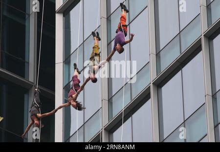 (151015) -- SHANGHAI, 15 ottobre 2015 -- i ballerini della compagnia di danza Bandaloop degli Stati Uniti eseguono balletti Sky vicino a un grattacielo a Shanghai, Cina orientale, 14 ottobre 2015. La performance è stata una prova per il 17° Shanghai International Arts Festival, che durerà dal 16 ottobre al 16 novembre. ) CHINA-SHANGHAI-SKY BALLET (CN) RenxLong PUBLICATIONxNOTxINxCHN Shanghai OCT 15 2015 ballerini della banda Loop Dance Troupe degli Stati Uniti eseguono lo Sky Ballet vicino a un grattacielo a Shanghai Cina orientale OCT 14 2015 The Performance What a Reprovsal for the 17th Shanghai International Arts Fes Foto Stock