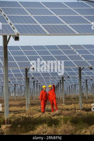 (151022) -- CHANGXING, 22 ottobre 2015 -- i lavoratori esaminano il più grande progetto fotovoltaico in agricoltura nella contea di Changxing, nella provincia dello Zhejiang nella Cina orientale, 22 ottobre 2015. Con un'area di 1.460 mu (97 ettari), il progetto da 30 megawatt ha condotto la sua operazione di prova alla fine di ottobre. Mentre i pannelli fotovoltaici sono utilizzati per la generazione di elettricità, i terreni sottostanti sono utilizzati per la coltivazione di colture da reddito. Si stima che nella contea di Changxing saranno ridotte ogni anno circa 10.000 tonnellate di carbone standard e 28.000 tonnellate di emissioni di anidride carbonica. ) (DHF) CINA-ZHEJIANG-AGRICOLTURA-FOTO PIÙ GRANDE Foto Stock