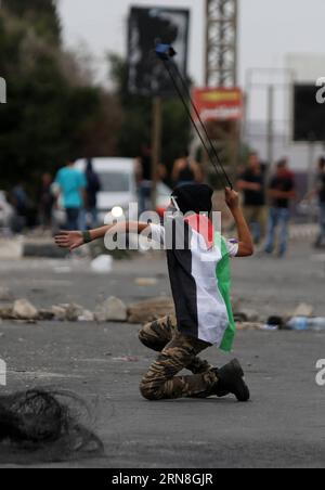 Un manifestante palestinese usa una fionda per lanciare pietre contro i soldati israeliani durante gli scontri al checkpoint israeliano di Hawwara vicino alla città di Nablus in Cisgiordania, il 23 ottobre 2015. Almeno 96 palestinesi sono rimasti feriti negli scontri scoppiati venerdì pomeriggio tra lanciatori di pietre palestinesi e soldati israeliani in Cisgiordania e nella Striscia di Gaza, hanno detto i medici. Ayman Nobani) MIDEAST-NABLUS-CLASHES EmadxDrimly PUBLICATIONxNOTxINxCHN un manifestante PALESTINESE usa una fionda per lanciare pietre verso i soldati israeliani durante gli scontri AL Checkpoint di Hawwara israeliano vicino alla CISGIORDANIA ci Foto Stock