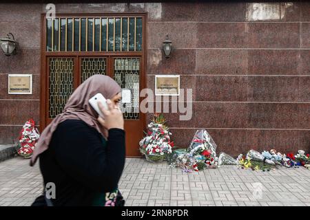 (151101) -- CAIRO, Nov. 1, 2015 -- An Egyptian woman walks by the flowers laid by mourners to pay homage to the plane crash victims in front of the Russian embassy in Cairo, Egypt, Nov. 1, 2015. Egyptian and international investigators on Sunday have begun probing the reasons of the Russian plane that crashed in Egypt s Sinai peninsula on Saturday which killed all 224 on board. ) EGYPT-CAIRO-RUSSIA-PLANE CRASH-MOURNING CuixXinyu PUBLICATIONxNOTxINxCHN   Cairo Nov 1 2015 to Egyptian Woman Walks by The Flowers laid by Morne to Pay Homage to The Plane Crash Victims in Front of The Russian Embassy Foto Stock