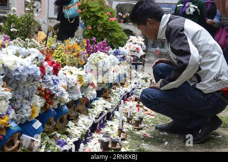 (151109) -- LA PAZ, 8 novembre 2015 -- Un uomo guarda i teschi durante la celebrazione del giorno della Natitas nel Cementario generale di la Paz, Bolivia, l'8 novembre 2015. Il giorno della Natitas si tiene l'ottavo giorno di novembre in Bolivia. I Natitas sono teschi umani che vengono curati e decorati dai credenti che li usano come amuleti credendo che servano come protezione. Il festival è un mix di culto ancestrale andino e credenze cattoliche che si tiene con rituali con fiori, cibo, leavs di coca, sigaretti, alcol, e gruppi musicali. I teschi di solito sono di persone sconosciute, bu Foto Stock