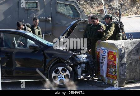 (151124) -- NABLUS, 24 novembre 2015 -- soldati israeliani si trovano sulla scena in cui un uomo palestinese è stato colpito dalle forze israeliane dopo aver sbattuto un'auto contro le truppe israeliane in un posto di blocco israeliano vicino alla città di Nablus in Cisgiordania, martedì 24 novembre 2015. Il palestinese ha speronato il suo veicolo in una pattuglia militare israeliana in Cisgiordania centrale martedì, ferendo quattro soldati, tra cui un ufficiale di alto rango, ha detto funzionari. ) MIDEAST-NABLUS-ATTACK AymanxNobani PUBLICATIONxNOTxINxCHN 151124 Nablus Nov 24 2015 soldati israeliani si trovano SULLA scena in cui un uomo PALESTINESE cosa sparato dalle forze israeliane A. Foto Stock