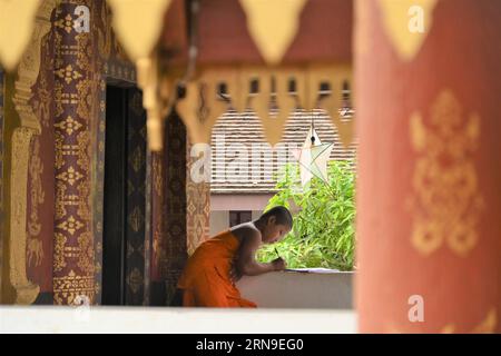 Giovane monaco buddista nel cortile di un tempio a Luang Prabang, Laos Foto Stock