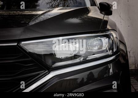 Moderno faro nero allo xeno per auto, vista frontale ravvicinata. Primo piano moderno dei fari Foto Stock