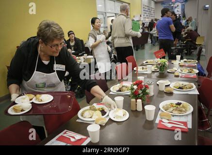 (151206) -- VANCOUVER, 5 dicembre 2015 -- Un volontario mette i piatti sul tavolo per i residenti durante il pasto all'evento annuale gratuito di Natale a Vancouver, Canada, 5 dicembre 2015. Circa 3.000 residenti che soffrono di povertà e senzatetto a Vancouver sono stati offerti pasti gratuiti dal 75° evento annuale gratuito di pasto di Natale della Union Gospel Mission per condividere la gioia prima del Natale. ) CANADA-VANCOUVER-FREE CHRISTMAS MEAL Liangxsen PUBLICATIONxNOTxINxCHN 151206 Vancouver DEC 5 2015 un volontario mette i piatti SUL tavolo per i residenti durante il pasto ALL'annuale pasto di Natale gratuito Foto Stock