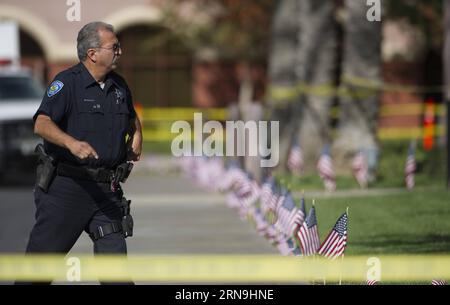 San Bernardino in der Woche nach der Schießerei (151207) - SAN BERNARDINO, 7 dicembre 2015 - Un poliziotto cammina di fronte all'edificio dell'Inland Regional Center dove 14 persone sono state uccise in una sparatoria di massa, a San Bernardino, California, Stati Uniti, 7 dicembre, 2015. gli investigatori credevano che la coppia sospettata che uccise 14 persone e ne ferì altre 21 in una sparatoria mortale a San Bernardino, nel sud della California, fosse stata radicalizzata per qualche tempo, ha detto l'FBI lunedì. ) U.S.-SAN BERNARDINO-SHOOTING-INVESTIGATION YangxLei PUBLICATIONxNOTxINxCHN San Bernardino nella settimana successiva Foto Stock