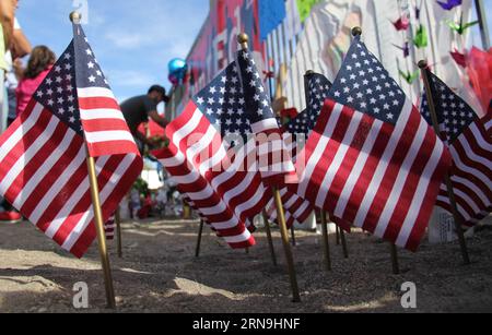 San Bernardino in der Woche nach der Schießerei (151207) -- SAN BERNARDINO, Dec. 7, 2015 -- National flags are placed near the building of the Inland Regional Center where 14 people were killed in a mass shooting, in San Bernardino, California, the United States, Dec. 7, 2015. Investigators believed that the suspect couple who killed 14 people and injured 21 others in a deadly shooting in San Bernardino of Southern California had been radicalized for some time, the FBI said on Monday. ) U.S.-SAN BERNARDINO-SHOOTING-MOURNING YangxLei PUBLICATIONxNOTxINxCHN   San Bernardino in the Week after the Stock Photo