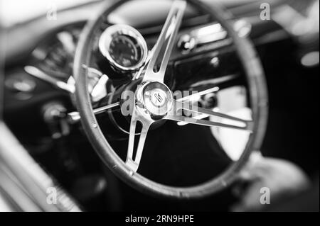 Foto a fuoco selettiva in bianco e nero di un volante Grant GT su un'auto più vecchia in una mostra nel parcheggio del Country Club Plaza a Sacramento. Foto Stock