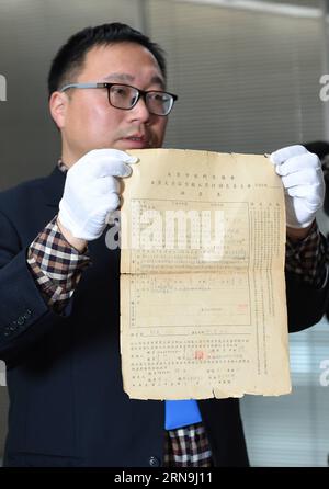 China präsentiert Forschungsergebnisse zum Massaker von Nanking (151208) -- NANCHINO, 8 dicembre 2015 -- Un membro dello staff dell'Archivio municipale di Nanchino mostra i file del massacro di Nanchino a Nanchino, capitale della provincia di Jiangsu della Cina orientale, l'8 dicembre 2015. La Cina ha pubblicato i fascicoli delle indagini sui crimini di guerra sul massacro di Nanchino prima della giornata commemorativa nazionale per l'atrocità. I 15 fascicoli sono solo una piccola selezione dei 2.784 che il Consiglio municipale provvisorio di Nanchino ha compilato tra luglio e novembre 1946 e che sono stati elencati nella memoria del Registro Mondiale da U Foto Stock