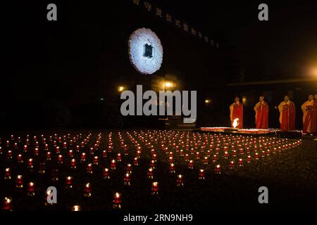 (151213) -- NANCHINO, 13 dicembre 2015 -- persone tra cui giovani, buddisti e stranieri assistono a una veglia di candela presso la sala commemorativa per le vittime del massacro di Nanchino da parte degli invasori giapponesi a Nanchino, capitale della provincia di Jiangsu della Cina orientale, il 13 dicembre 2015, la seconda giornata commemorativa nazionale cinese per le vittime del massacro di Nanchino. ) CHINA-NANJING-VIGIL-NANJING MASSACRE-PRAY(CN) jixchunpeng PUBLICATIONxNOTxINxCHN 151213 Nanjing DEC 13 2015 celebrità tra cui giovani buddisti e stranieri partecipano a una Veglia di candela PRESSO la sala commemorativa per le vittime del massacro di Nanjing da parte giapponese Foto Stock