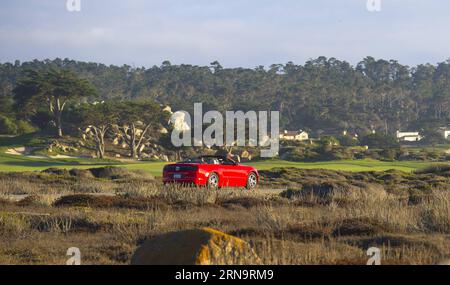 (151217) -- CALIFORNIA, 17 dicembre 2015 -- la foto scattata nel settembre 2013 mostra un'auto sportiva rossa che corre su 17-Mile Drive in California, Stati Uniti. La 17-Mile Drive è ampiamente riconosciuta come una delle strade più panoramiche del mondo. Il famoso punto di riferimento costiero attraversa Pacific Grove fino a Pebble Beach, dalla suggestiva costa del Pacifico alla maestosa foresta del Monte). U.S.-CALIFORNIA-17-MILE DRIVE-SCENOGRAFIA YangxLei PUBLICATIONxNOTxINxCHN 151217 California DEC 17 2015 foto scattate nel settembre 2013 mostra una Red Sports Car CHE CORRE SU 17 Mile Drive in California Stati Uniti 17 Mile Dr Foto Stock
