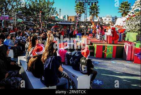 Tourists watch the performance at the Universal Studios Hollywood theme park in Los Angels, California of the United States, on Dec. 18, 2015. The theme park started a Crinchmas celebration for upcoming Christmas and New Year from Dec. 18 to Jan. 3, 2016. The Grinch came from How the Grinch Stole Christmas which was written by famous American children s book writer Dr. Seuss and later made into a Universal movie with the same title in 2000. )(azp) US-HOLLYWOOD-GRINCHMAS ZHANGxCHAOQUN PUBLICATIONxNOTxINxCHN   tourists Watch The Performance AT The Universal Studios Hollywood Theme Park in Los An Foto Stock
