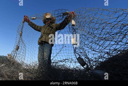 (151227) -- HARBIN, 27 dicembre 2015 -- Un pescatore si prepara a gettare la rete sul lago Changling, Harbin, capitale della provincia di Heilongjiang della Cina nordorientale, 27 dicembre 2015. La pesca invernale come progetto commerciale e turistico è iniziata in condizioni climatiche fredde con meno 20 gradi Celsius). (wf) CINA-HARBIN-PESCA INVERNALE (CN) WangxJianwei PUBLICATIONxNOTxINxCHN 151227 Harbin DEC 27 2015 un pescatore si prepara alla rete GHIACCIATA SUL lago Chang Ling Harbin capitale della provincia di Heilongjiang del nord-est della Cina DEC 27 2015 il progetto invernale di pesca come impresa e turismo è iniziato a Chil Foto Stock