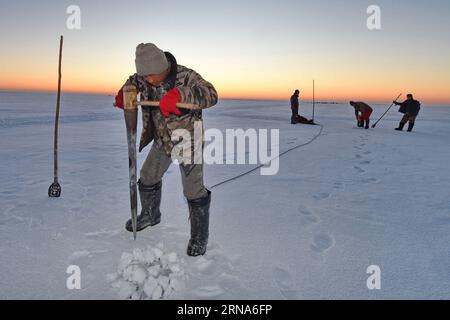 (160109) -- SONGYUAN, 8 gennaio 2016 -- Un pescatore trapana un buco su ghiaccio spesso sul lago Chagan nella città di Songyuan, nella provincia di Jilin della Cina nordorientale, 8 gennaio 2016. Il lago Chagan, noto per la tradizionale pesca invernale che risale all'epoca preistorica, è l'unico luogo che salva il più antico metodo di pesca mongolo. Durante l'annuale festival della pesca invernale, che si tiene per ricordare la vecchia tradizione della pesca invernale, i pescatori prima praticano molti fori attraverso il ghiaccio spesso e poi mettono una rete sotto il ghiaccio, la rete viene infine estratta da un argano da traino. Il lago ha incastrato un Guinnes Foto Stock